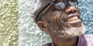 man looking up wearing a hat and sunglasses